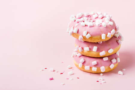 Tower of pink glazed donuts with marshmallows on pinkの写真素材