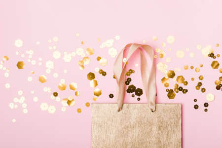 Golden paper shopping bag and trendy hexagonal sparkles on pinkの写真素材