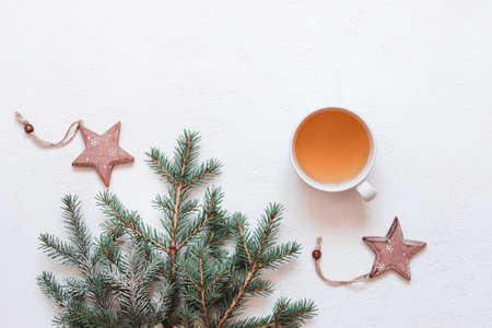 Natural Christmas decor made of fir branches and cup of green tea on whiteの写真素材