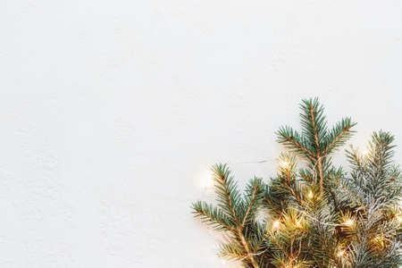 Neutral Christmas composition of fir branches and golden light garland.の写真素材