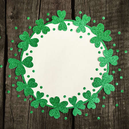 Round frame of shiny shamrocks and confetti. St. Patricks Day background.の写真素材