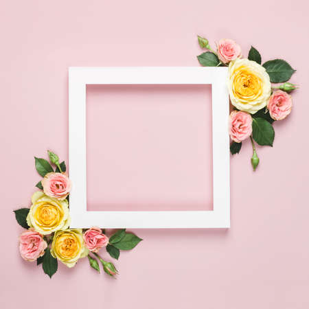 White paper Frame of beautiful roses on pink background. Minimal holiday concept with copy space....