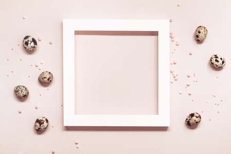 White Frame and quail eggs over pink pastel background. Happy easter minimal concept.の写真素材