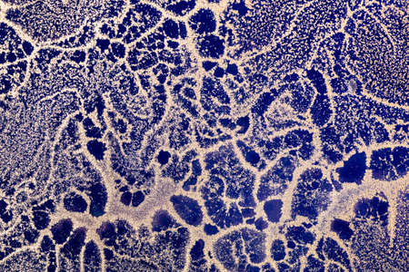 Acrylic Fluid Art. Abstract waves of gold grains pattern on dark blue