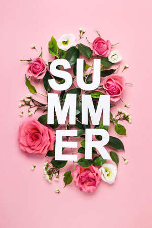 Paper word Summer, green leaves and buds of rose flowers on pastel pink background. Nature season concept.の写真素材