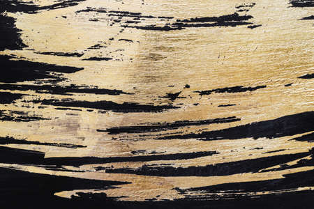 Gold potal background or texture. Abstract shining brush strokes on black.