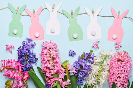 Happy easter greeting card. Multicolored hyacinth flowers and paper bunnies garland. Easter concept. Flat layの写真素材