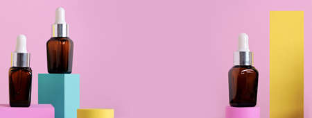 Beauty natural skincare product banner. Serum or Collagen Dropper Bottles on different geometric podiums. Skincare products presentationの写真素材