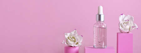 Beauty skincare product banner. Serum bottle and flowers on different geometric podiums for branding and packaging presentationの写真素材