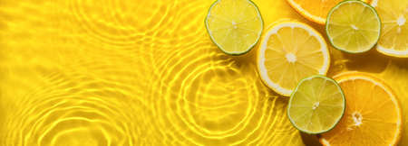Citrus fruits in yellow water banner with concentric circles and ripples. Refreshing summer concept, Copy spaceの写真素材