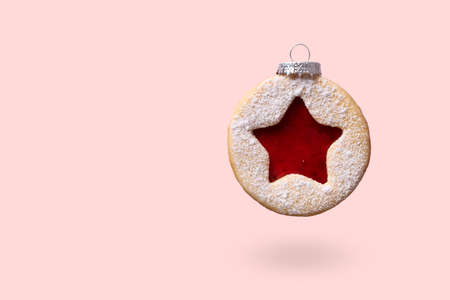 Christmas bauble made of Linzer cookies levitate on pink background. Minimal Christmas backgroundの写真素材