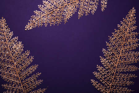 Christmas violet background. Shining golden floral frame made of leavesの写真素材