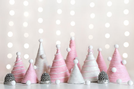 Diy Christmas trees is made of pink yarn. Eco-friendly fluffy Christmas decor on shining backgroundの写真素材