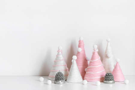 Diy Christmas trees is made of pink yarn. Eco-friendly fluffy Christmas decor on white backgroundの写真素材