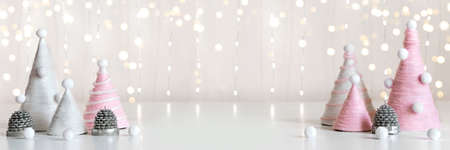 Diy Christmas trees is made of pink yarn. Eco-friendly fluffy Christmas decor on shining bannerの写真素材