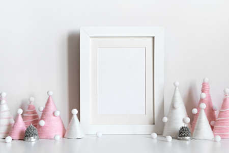 Diy Christmas trees is made of pink yarn and mockup frame on table. Front view mockup. Eco fluffy Christmas decorationの写真素材