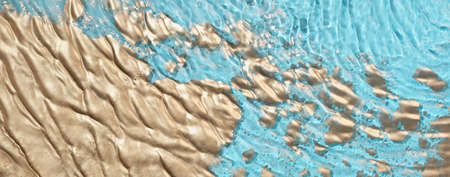 Cosmetic moisturizer micellar water. Gold powder particles forms on water surface. Abstract liquid...