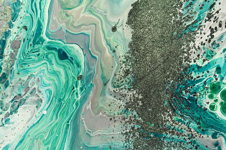 Fluid Art acrylic paints. Abstract mixing green waves and grains of sand. Liquid flows splashes....