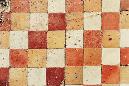 Old and dirty crumbling ceramic tile floor. Grunge interior background closeup