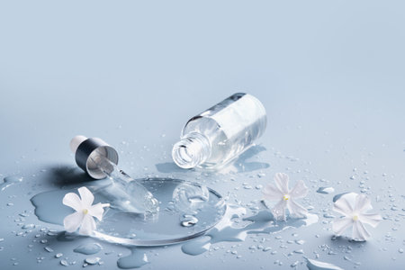 Pipette, cosmetic product and White flowers in glass slide on blue background, selective focusの写真素材