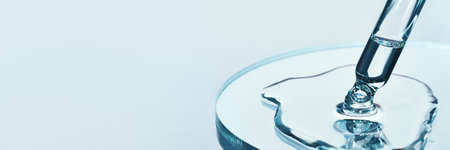 Pipette with sample of cosmetic product in petri dish on blue banner, selective focus.の写真素材