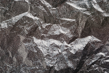 Silver crumpled foil textural background