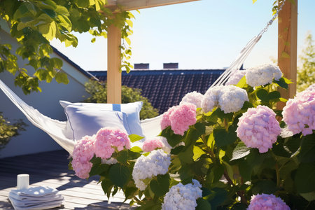 Outdoor roof terrace with hammock and potted blooming hydrangea overlooking the sky and roofsの素材
