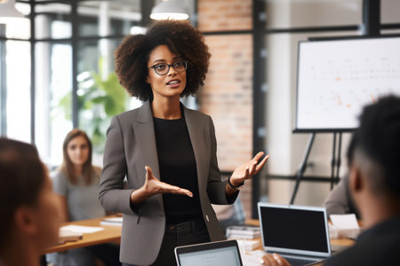 Confident professional black businesswoman makes presentation of project in boardroom settingの素材