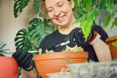 Happy woman replanting succulents in bright room. Home gardening and plant care