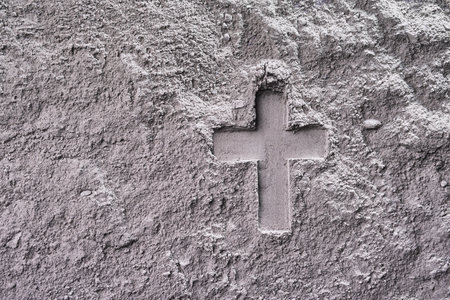 Cross imprint in gray ash surface. Ash Wednesday
