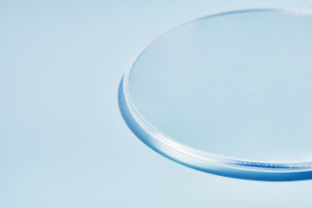 Minimalist glass circle on light blue background with soft shadowsの写真素材