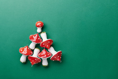 Ceramic Amanita muscaria ornaments arranged in christmas tree shape on teal green backgroundの写真素材