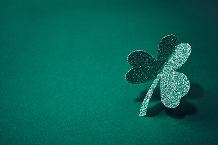 Glittering shamrock standing on green background representing good luck