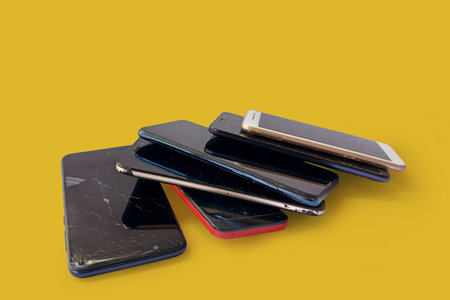 Smartphones with scratched tempered glass isolated on yellow backgroundの写真素材