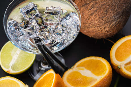Mint ice cocktail tropical beverage drink alcohol. Iced drink on a background of tropical fruits.