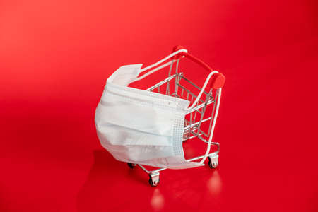 Medical masks, protection against viruses, diseases on a red background, shopping trolley.の写真素材