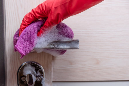 A hand in a red glove washes the door.の写真素材