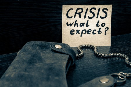 wallet and a sticker with the words crisis, what to expectの写真素材