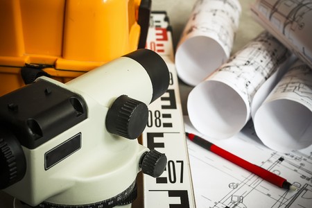 Measuring geodetic instruments and drawings are on the tableの写真素材