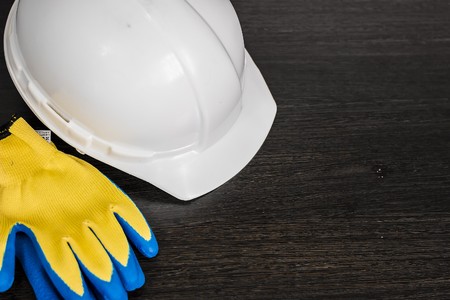 white helmet, gloves, and drawings are on the tableの写真素材