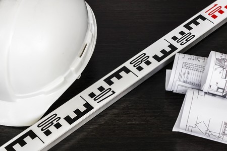 white helmet, gloves, and drawings are on the tableの写真素材