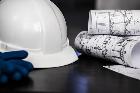 white helmet, gloves, and drawings are on the tableの写真素材