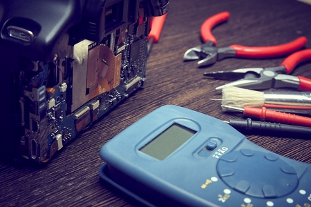 On the black glass is disassembled for repair digital SLR camera, which is photographed close-up....
