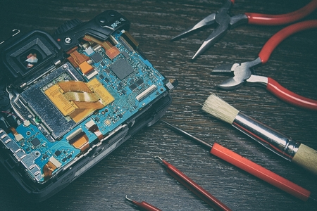 On the black glass is disassembled for repair digital SLR camera, which is photographed close-up. Can be used as a concept or as a backgroundの写真素材