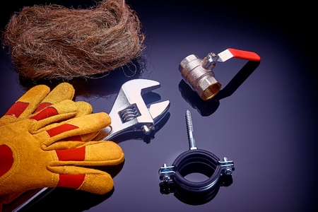 Set plumbing and tools on a green background. The fit, adjustable wrench for plumbing pipes and...