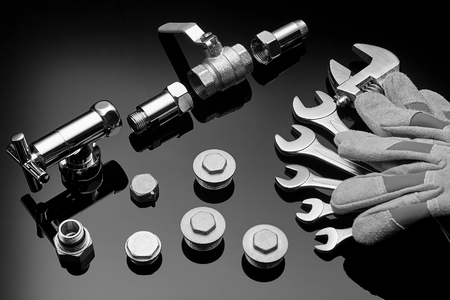 Plumbing accessories and tools on a dark background photographed close-upの写真素材