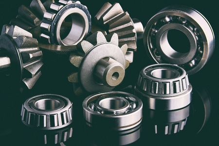 Gears, bearings and differential are on the table in the dark. Can be used as a background.