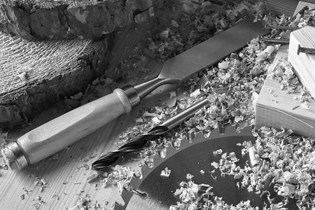 A set of chisels, drills on wood and boards lies on a dark background.の写真素材