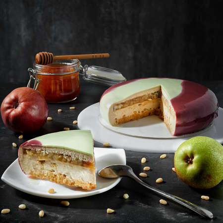 Delicate natural mousse cake with berries and nuts, covered with colored glaze on a dark background. A real festive decorationの写真素材