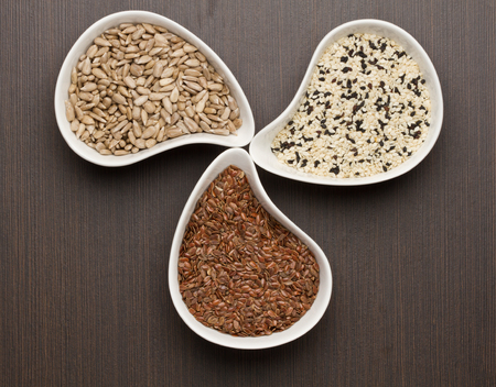 Sesame,flax and sunflower seeds in white bowlの写真素材